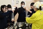 災害用炊飯袋にコメを入れ、非常食作りに挑戦する生徒ら＝２７日、鳥取市西品治の鳥取城北高