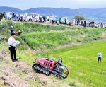 大勢の参加者が見守る中で行われた最新の草刈り機の実演＝２３日、新温泉町丹土