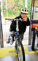 自転車を担いで列車に乗り込むツアー参加者＝９日、大山町御来屋のＪＲ名和駅