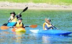 列になって沖へとカヌーをこぐ児童ら＝３日、香美町香住区の柴山湾