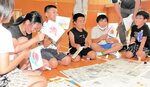 ハタハタのキャラクター「はたがみさま」を描いた旗を作る児童たち＝３０日、香美町香住区大野の長井小