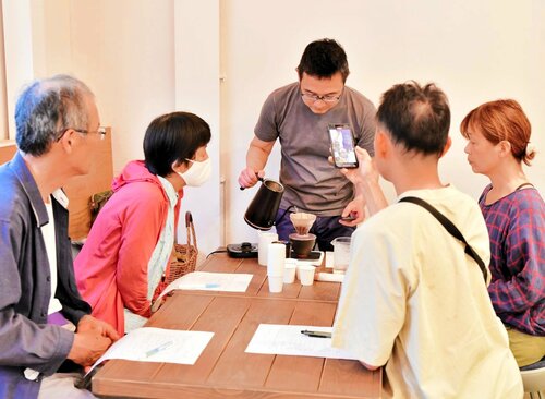横山さん（中央）からコーヒーの入れ方を学ぶ参加者