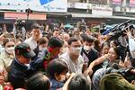 　タイ・チェンマイの市場を訪れたタクシン元首相（中央）＝３月１４日（共同）