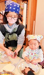 チョコクランチの材料となる板チョコレートを割る親子＝１４日、香美町小代区忠宮の「いこいの里」