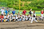 上園さんの投球を真剣なまなざしで見つめる子どもたち＝９日、鳥取市布勢のヤマタスポーツパーク野球場