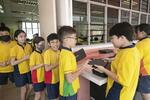 　ＡＩ教材を使うノートパソコンを取りに行くレークサイド小学校の児童ら＝２０２３年１１月、シンガポール（共同）