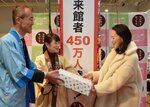 ４５０万人目の来館者となり、鳥取、岡山両県の特産品を受け取る関さん（右）＝１９日、東京都港区のとっとり・おかやま新橋館