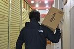 　ネット通販大手アマゾンの荷物を運ぶ男性＝２０２２年１０月、神奈川県横須賀市