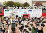 　優勝パレードに詰めかけた大勢の人たちに手を振る阪神の選手ら＝２３日午前、神戸市のメリケンパーク