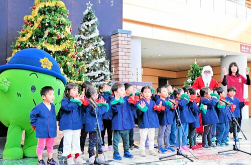 ツリーの下で元気よく歌う園児ら＝４日、倉吉市のエースパック未来中心