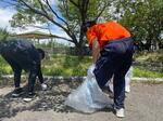 　しまなみ海道サイクリングの道中、公園の清掃活動を行う少年（右）＝７月、愛媛県今治市