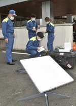  スターリンクのアンテナ（手前）とタブレット端末を接続する県職員＝１１日、鳥取県第２庁舎前 