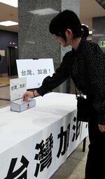 台湾地震の被災地復興を願い募金する県職員ら＝８日、鳥取県庁