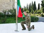 　１５日、ナゴルノカラバフのアグデレで国旗を掲げるアゼルバイジャンのアリエフ大統領（アゼルバイジャン大統領府提供・ロイター＝共同）