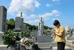 　ミャンマーで銃撃され亡くなった映像ジャーナリスト長井健司さんの墓前で、手を合わせる妹の小川典子さん＝２７日午前、愛媛県今治市