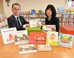 山本局長（左）から書籍を受け取る村田館長＝１２日、米子市西町の市児童文化センター