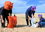 ハロウィーンの仮装をして砂丘清掃をする参加者＝６日、鳥取市の鳥取砂丘