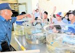 威勢良く手を上げて魚を競り落とす児童たち＝１０日、香美町香住区の香住高