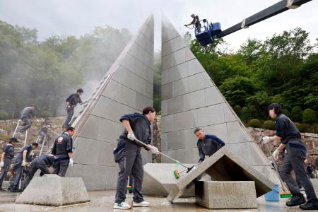 　日航ジャンボ機墜落事故の追悼施設「慰霊の園」を清掃する、同社とグループ会社の社員ら＝２０日午後、群馬県上野村
