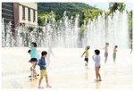 噴水の水を浴びてはしゃぐ子どもたち＝１３日、倉吉市駄経寺町の倉吉パークスクエア