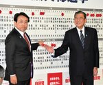 当選確実の報を受けて、石破氏（右）と共に自身の名前に花を付ける赤沢氏＝２７日午後９時４７分、東京・永田町の自民党本部