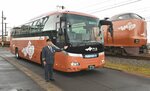 特急やくもの新型車両のデザインでラッピングされたバス（手前）＝２０日、島根県出雲市の後藤総合車両所出雲支所