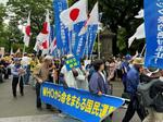 集会後、デモ行進に向かう参加者。日の丸を掲げる人たちが目立った＝５月３１日、東京都内