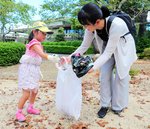 ごみを探して集めて回る親子連れ＝１４日、倉吉市仲ノ町の打吹公園