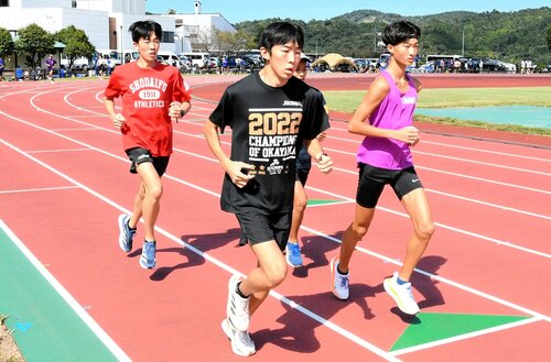 コース上をジョギングする日本海駅伝出場校の選手ら＝１２日、倉吉市営陸上競技場