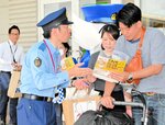 チラシを配って特殊詐欺被害の防止を呼びかける警察官（左）＝８月、日吉津村日吉津のイオンモール日吉津