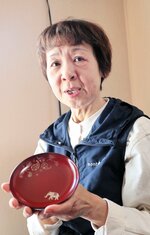 亡くなった島田怜奈さんが絵を描いた作品を手にする吉田ひとみさん＝４月、石川県輪島市