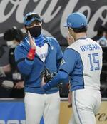 　巨人戦で完投した上沢直之投手（右）を迎える日本ハムの新庄監督＝２０２２年５月、札幌ドーム