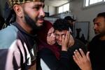 　パレスチナ自治区ガザ中部デールバラハで、イスラエル軍の攻撃で死亡した親族を悼む人々＝１９日（ＡＰ＝共同）