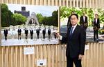 　「２０２３年報道写真展」を訪れ、Ｇ７広島サミットの写真（左）などにサインした岸田首相＝２０日午前、東京都中央区の日本橋三越本店