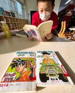 　北京市内の図書館で、中国語に翻訳された鳥山明さんの代表作「ドラゴンボール」を読む子ども＝８日（共同）