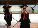 女子個人決勝　河本（左）が果敢にスネを狙い、延長戦の末に勝利を収める＝鳥取市武道館