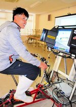 自転車シミュレーターで走行時の注意点を確認する実習生＝新温泉町芦屋の浜坂漁協