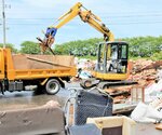 重機でトラックに積み込まれる災害ごみ＝１１日、香美町香住区油良の矢田川クリーンセンター跡地