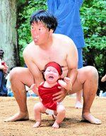 元気な泣き声を上げながら土俵入りする赤ちゃん＝２４日、新温泉町飯野の巌山神社