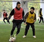 サッカー元日本代表の稲本さん（手前左）らとプレーで交流する参加者＝２９日、鳥取市吉成３丁目の市民体育館