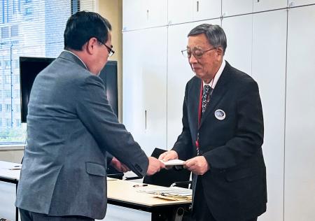 　総務省の担当者（左）に要望書を手渡す兵庫県選挙管理委員会の永田秀一委員長＝１７日午後、総務省