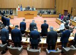 １分間の黙とうをささげる県執行部や県議ら＝１１日、鳥取県議会議場