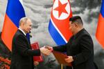 　１９日、北朝鮮・平壌での調印式で、文書を交換する金正恩朝鮮労働党総書記（右）とロシアのプーチン大統領（ＡＰ＝共同）