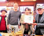 福岡からの夫婦に再訪記念の色紙を書いて手渡す池淵さん（右）