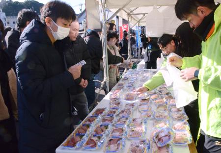 　石川県能登町宇出津地区の冬の恒例イベント「寒ぶりまつり」で、ブリを買い求める人たち＝１９日午前