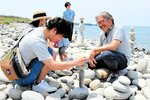 久保田さん（右）に教わりながら石を積み上げる来訪者