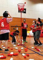 玉入れ競争で、かごを目がけて紅白の玉を投げる生徒ら＝１６日、鳥取市湖山町北６丁目の湖東中