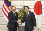 　会談前にマレーシアのアンワル首相（左）と握手する岸田首相＝２３日午後、首相官邸