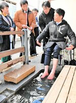 車いすに座った状態での足湯利用の危険性と改善策について関係者と意見を交わす斎藤知事（右）＝８日、豊岡市城崎町