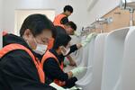 　出雲大社の敷地内にあるトイレを清掃するリクシルの社員ら＝２６日午前、島根県出雲市